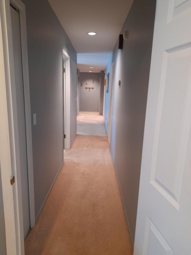 corridor featuring recessed lighting, light carpet, and baseboards