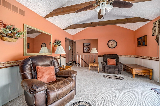 living room with a textured ceiling, lofted ceiling with beams, visible vents, wainscoting, and carpet