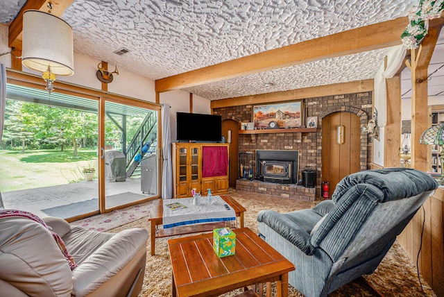 living room featuring arched walkways, a textured ceiling, brick wall, visible vents, and beamed ceiling