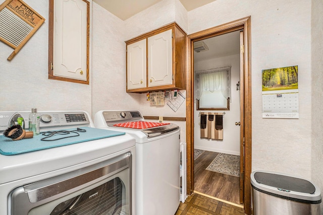 laundry room with parquet floors, cabinet space, and separate washer and dryer