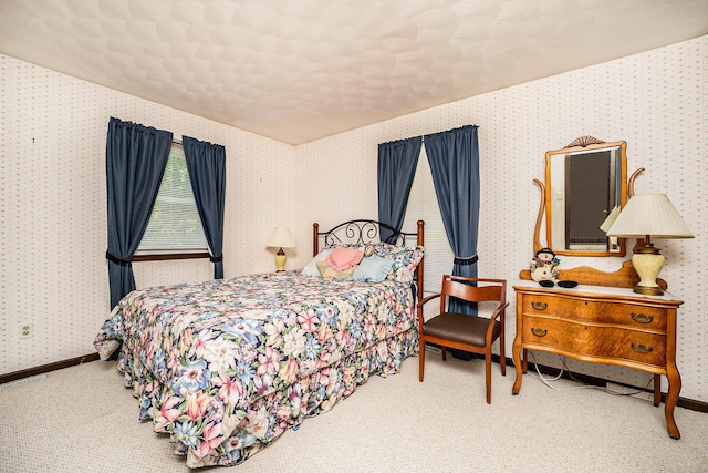 carpeted bedroom with wallpapered walls and baseboards