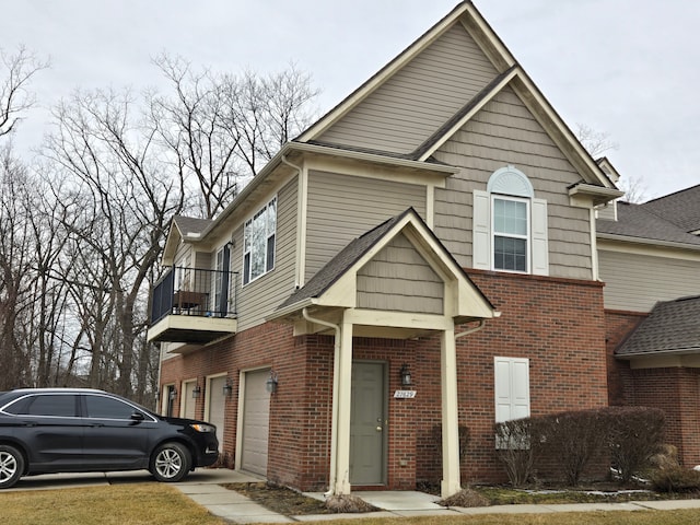 traditional-style house with brick siding, a balcony, and an attached garage