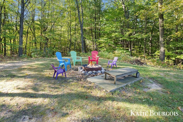 view of yard with a fire pit and a forest view