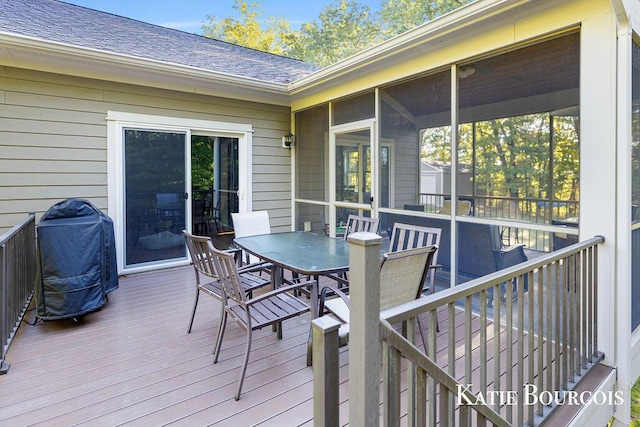 wooden deck with an outbuilding, outdoor dining area, a sunroom, a grill, and a shed