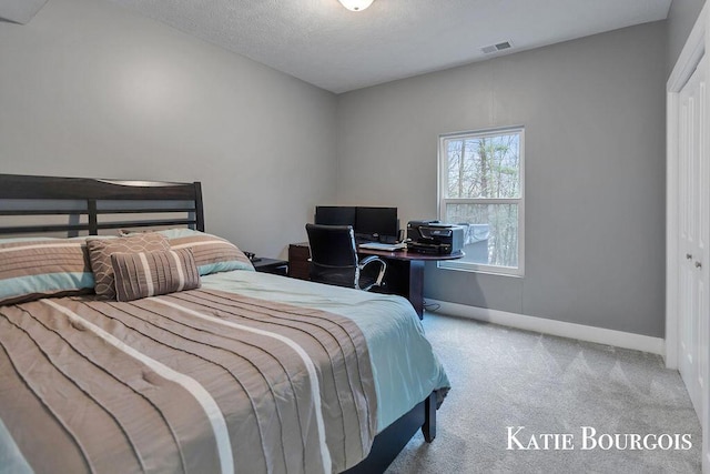 bedroom featuring carpet, visible vents, a textured ceiling, and baseboards