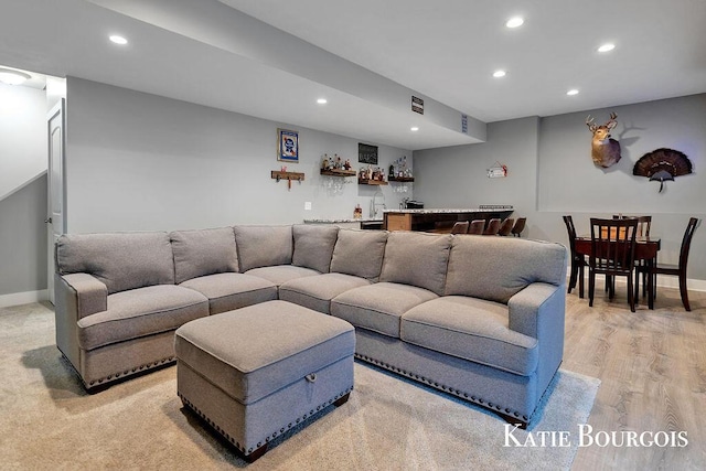 living area featuring baseboards, light wood finished floors, indoor wet bar, and recessed lighting