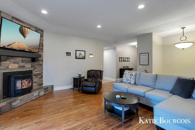 living room with a fireplace, recessed lighting, wood finished floors, and baseboards