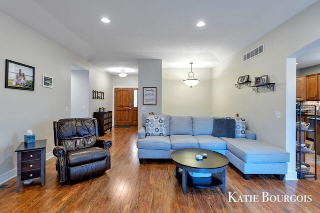 living area with baseboards, visible vents, wood finished floors, and recessed lighting