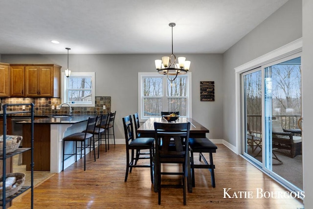 dining room featuring a notable chandelier, wood finished floors, and baseboards