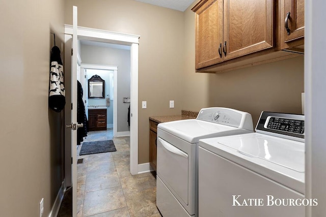 washroom with washing machine and dryer, cabinet space, and baseboards