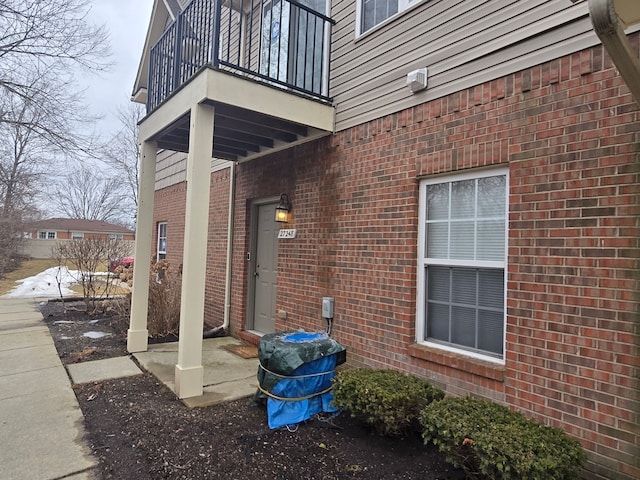 view of side of property with a balcony and brick siding