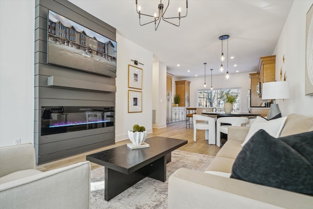 living area with a notable chandelier, recessed lighting, visible vents, baseboards, and light wood-style floors