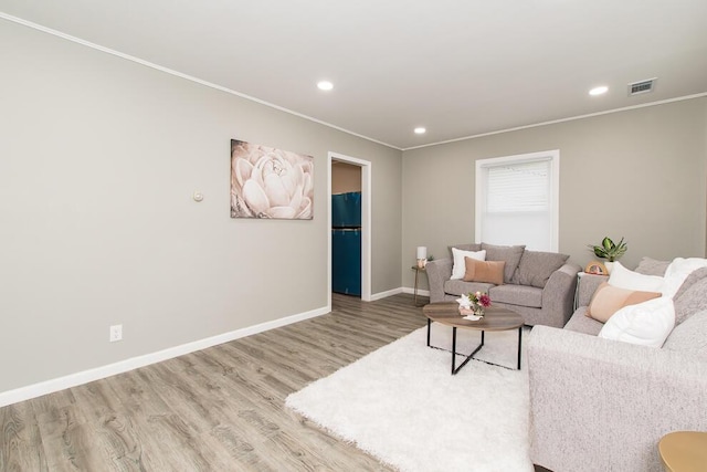 living area featuring crown molding, baseboards, wood finished floors, and recessed lighting