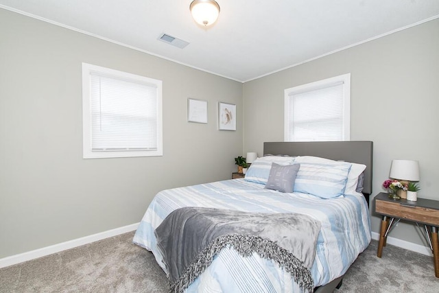 carpeted bedroom featuring visible vents, baseboards, and ornamental molding