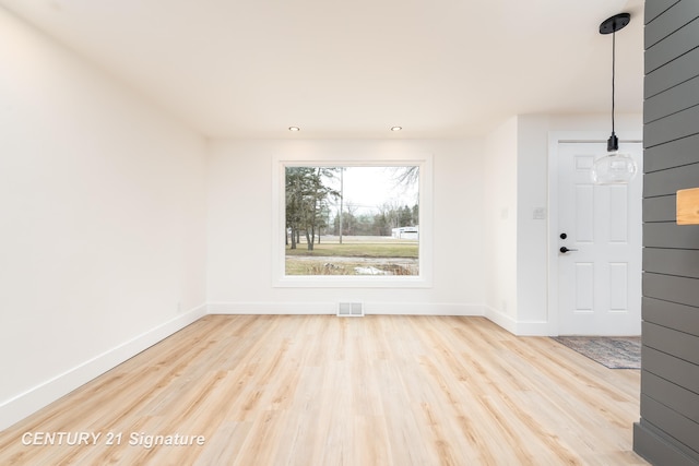 empty room with recessed lighting, wood finished floors, visible vents, and baseboards