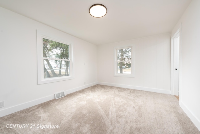 carpeted empty room with visible vents and baseboards