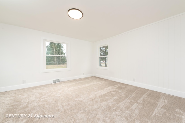 spare room with carpet flooring, visible vents, and baseboards