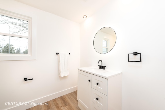 bathroom with vanity, baseboards, and wood finished floors