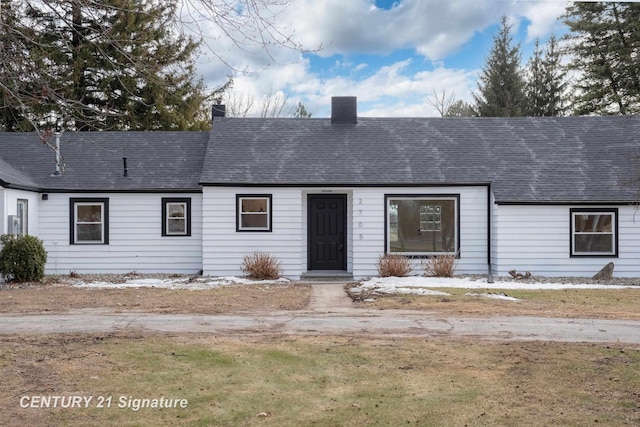 view of front of property featuring a shingled roof and a chimney