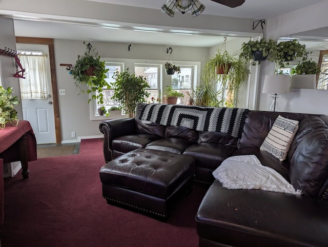 carpeted living area featuring a ceiling fan and baseboards