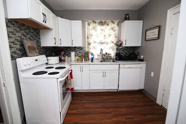 kitchen featuring white appliances, a sink, white cabinets, light countertops, and dark wood finished floors