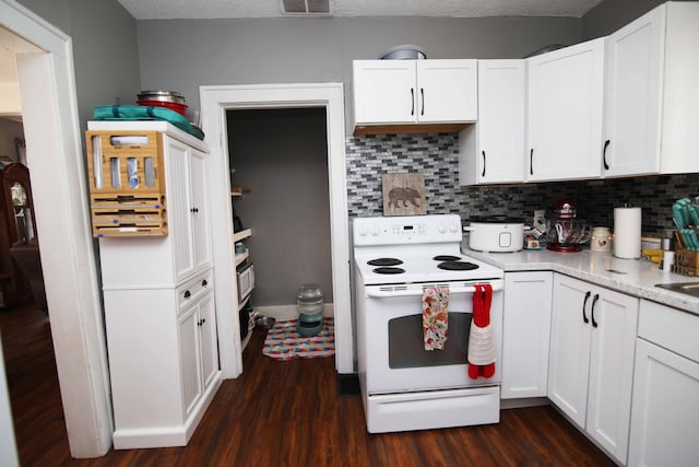 kitchen with electric stove, white cabinets, backsplash, and dark wood-style flooring