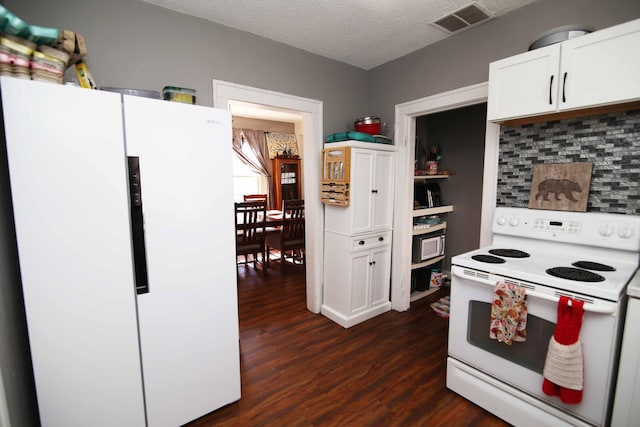 kitchen featuring dark wood-style flooring, visible vents, white cabinets, a textured ceiling, and white appliances