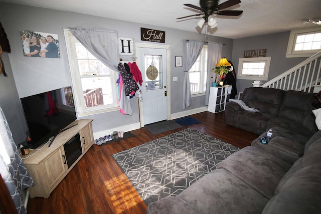 living area featuring baseboards, ceiling fan, dark wood-type flooring, stairs, and a textured ceiling