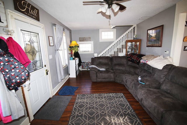 living area with visible vents, stairway, ceiling fan, a textured ceiling, and wood finished floors