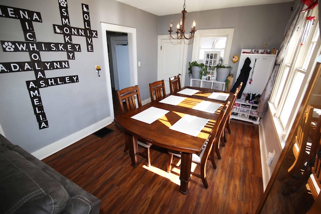 dining area featuring baseboards, visible vents, an inviting chandelier, and wood finished floors