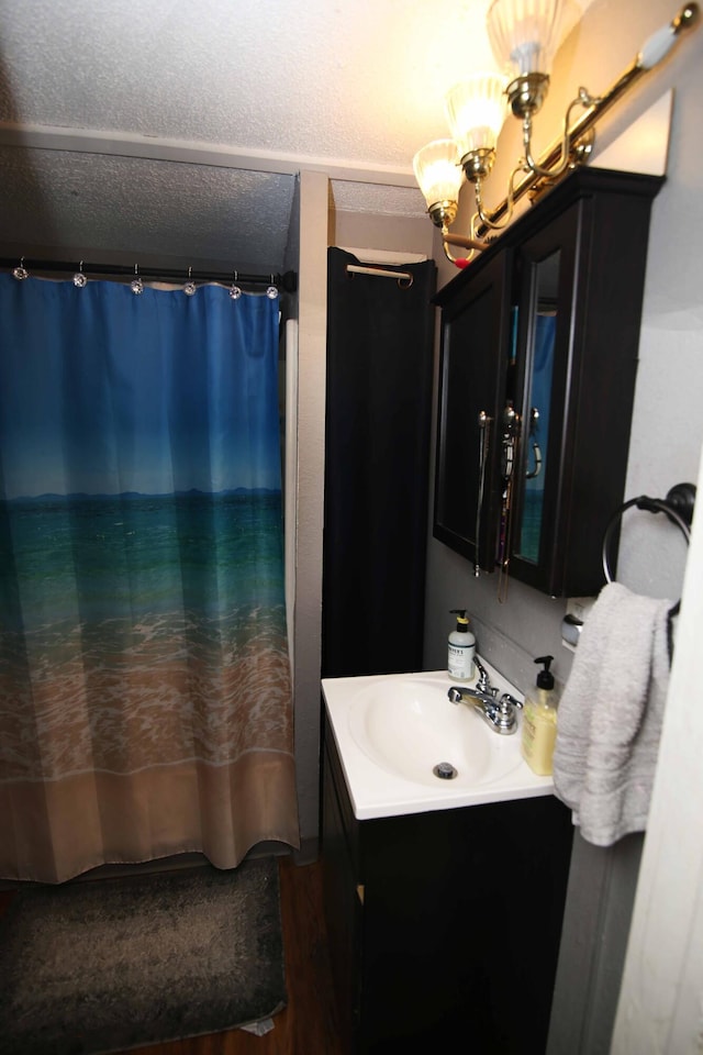 bathroom with a chandelier, curtained shower, a textured ceiling, and vanity