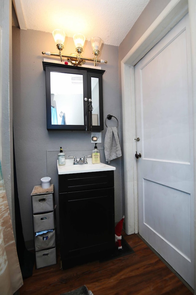 bathroom featuring a textured ceiling, wood finished floors, and vanity