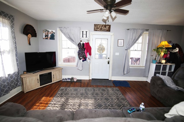 living room featuring baseboards, dark wood finished floors, and a ceiling fan