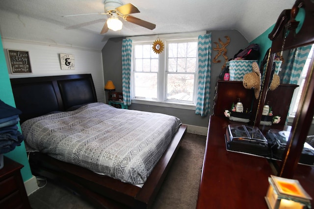 bedroom with lofted ceiling, a textured ceiling, a ceiling fan, and baseboards