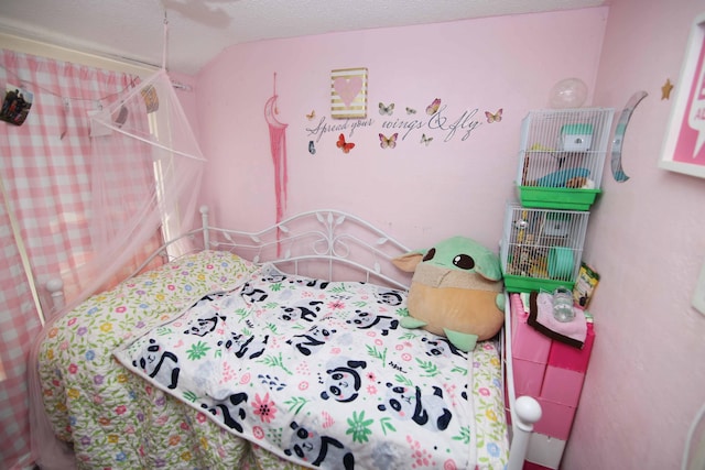 bedroom with lofted ceiling and a textured ceiling