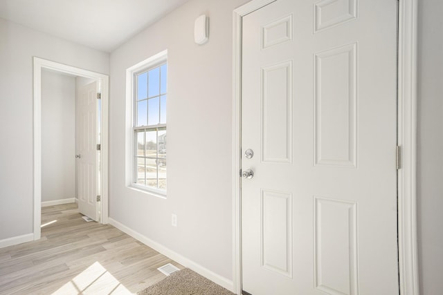 foyer featuring light wood-type flooring, visible vents, and baseboards