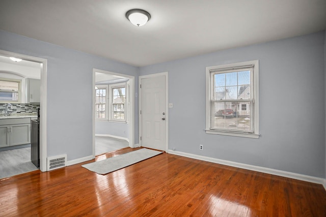 entryway featuring baseboards, visible vents, and wood finished floors