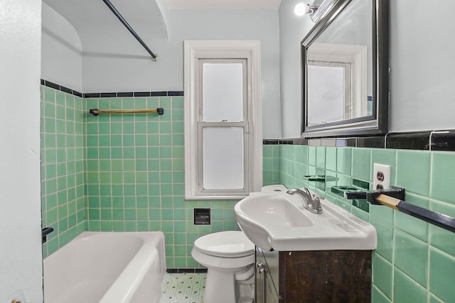 bathroom featuring toilet, a wainscoted wall,  shower combination, vanity, and tile walls