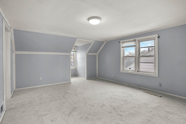 additional living space with carpet, plenty of natural light, baseboards, and vaulted ceiling