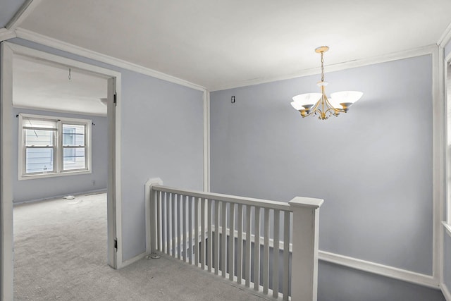 corridor featuring an inviting chandelier, ornamental molding, carpet flooring, an upstairs landing, and baseboards