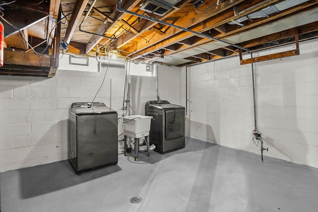 basement with separate washer and dryer and a sink