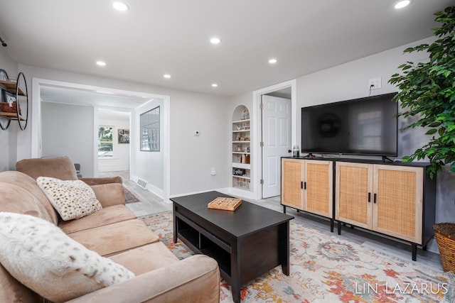 living room featuring baseboards, light wood finished floors, visible vents, and recessed lighting