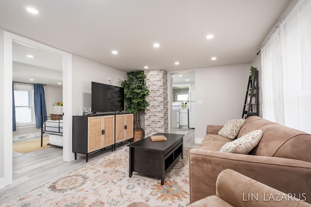 living room featuring baseboards, light wood-style floors, and recessed lighting