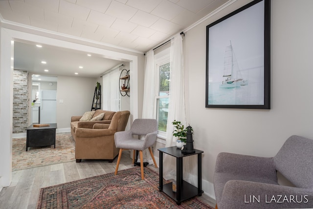 living room featuring baseboards, ornamental molding, wood finished floors, and recessed lighting