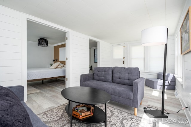 living area featuring light wood-style floors and ornamental molding