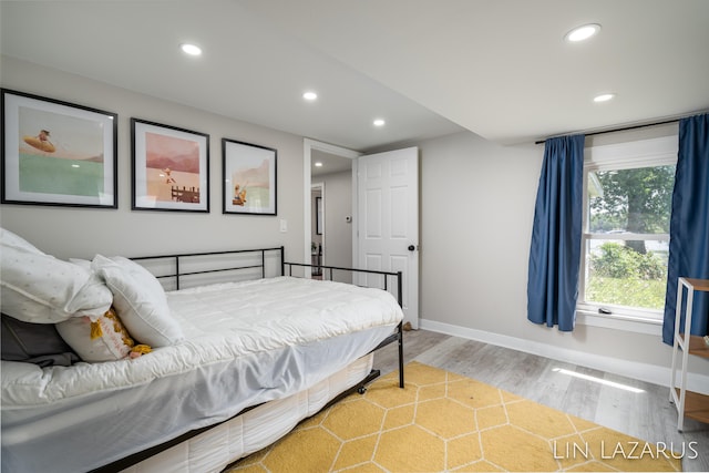 bedroom with baseboards, wood finished floors, and recessed lighting