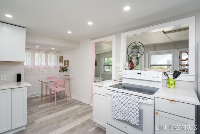 kitchen with light wood-style flooring, recessed lighting, light countertops, a wealth of natural light, and white range with electric cooktop