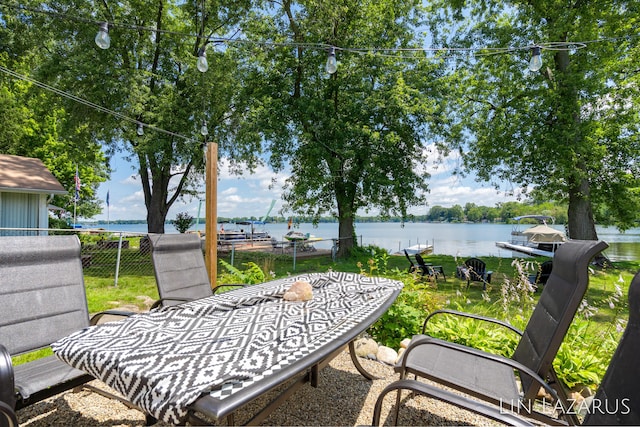 view of patio / terrace featuring a water view and fence