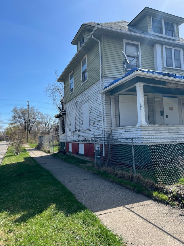 3674 Mount Elliott St, Detroit, MI 48207 - view of property exterior featuring fence, covered porch, and a lawn
