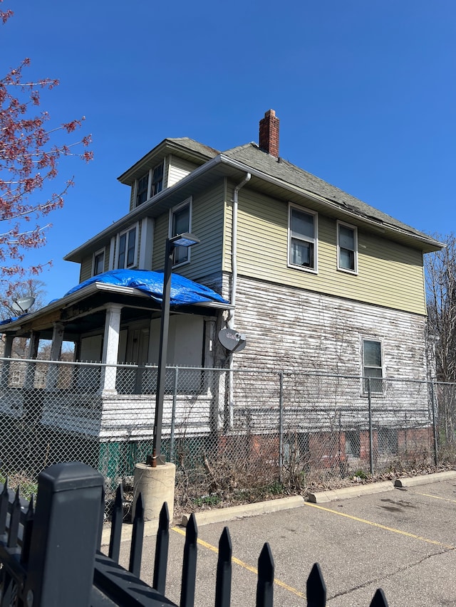 3674 Mount Elliott St, Detroit, MI 48207 - view of side of home featuring fence and a chimney